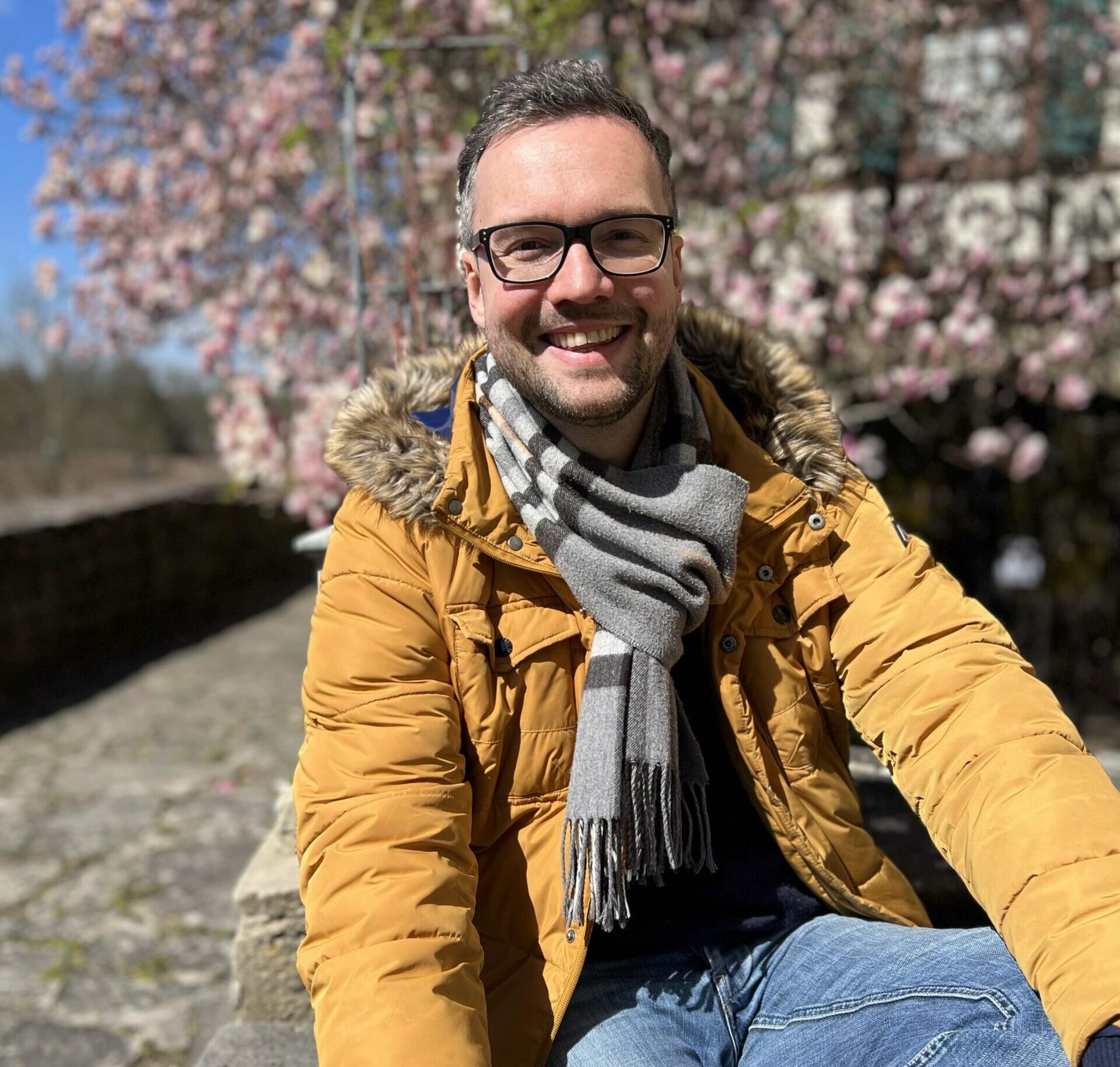 Frank sitzt vor einem Baum