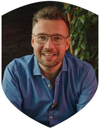 Frank Lauterbach, Inhaber der lauterbach kreativbetreuung, Blick in die Kamera. Er trägt ein Blaues Hemd und eine Brille. Das Bild ist im Rahmen des Formats - der Marketingexperte entstanden, in dem er schlechte und gute Werbung analysiert.